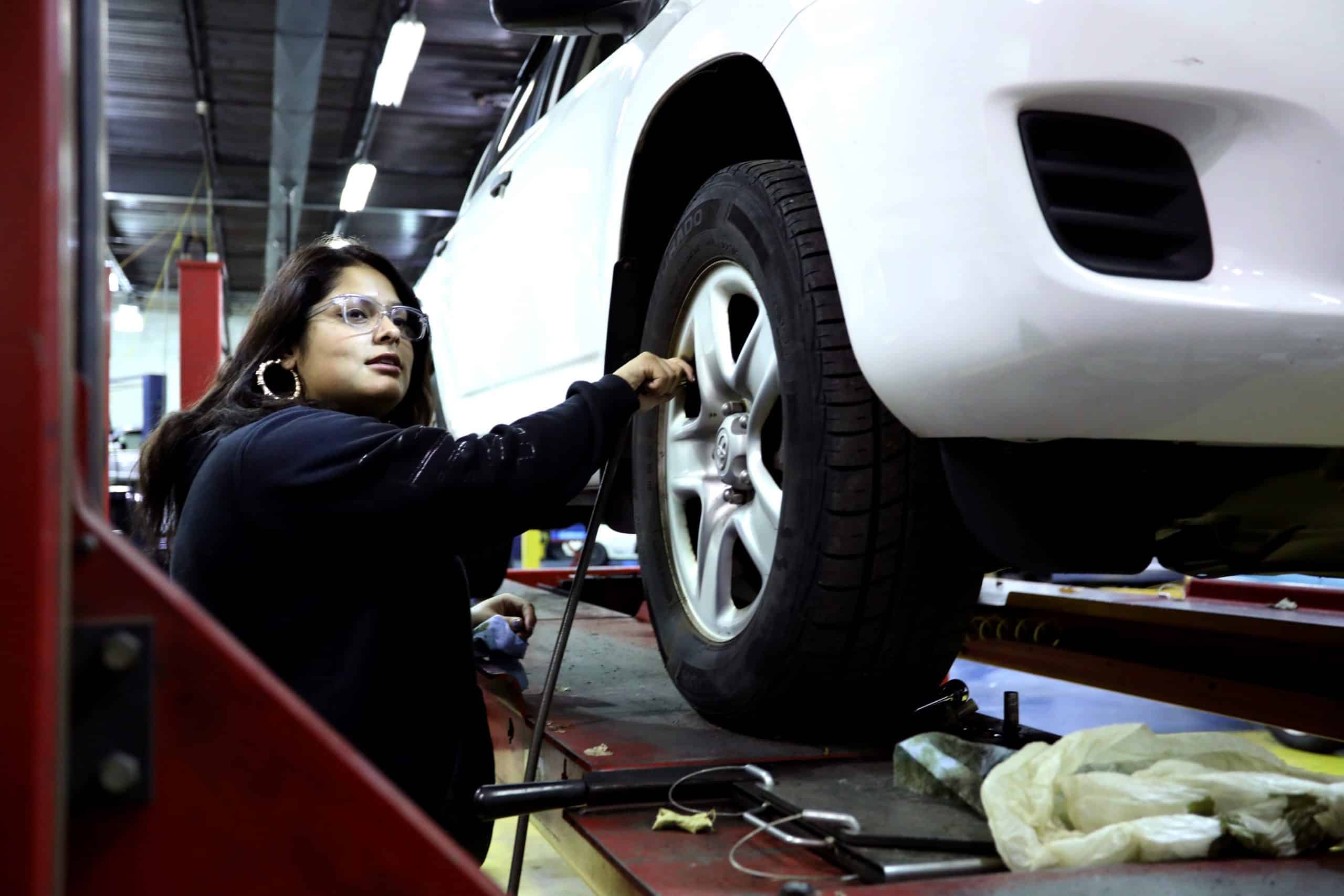 Automotive Technology Student Working on Wheel in Garage