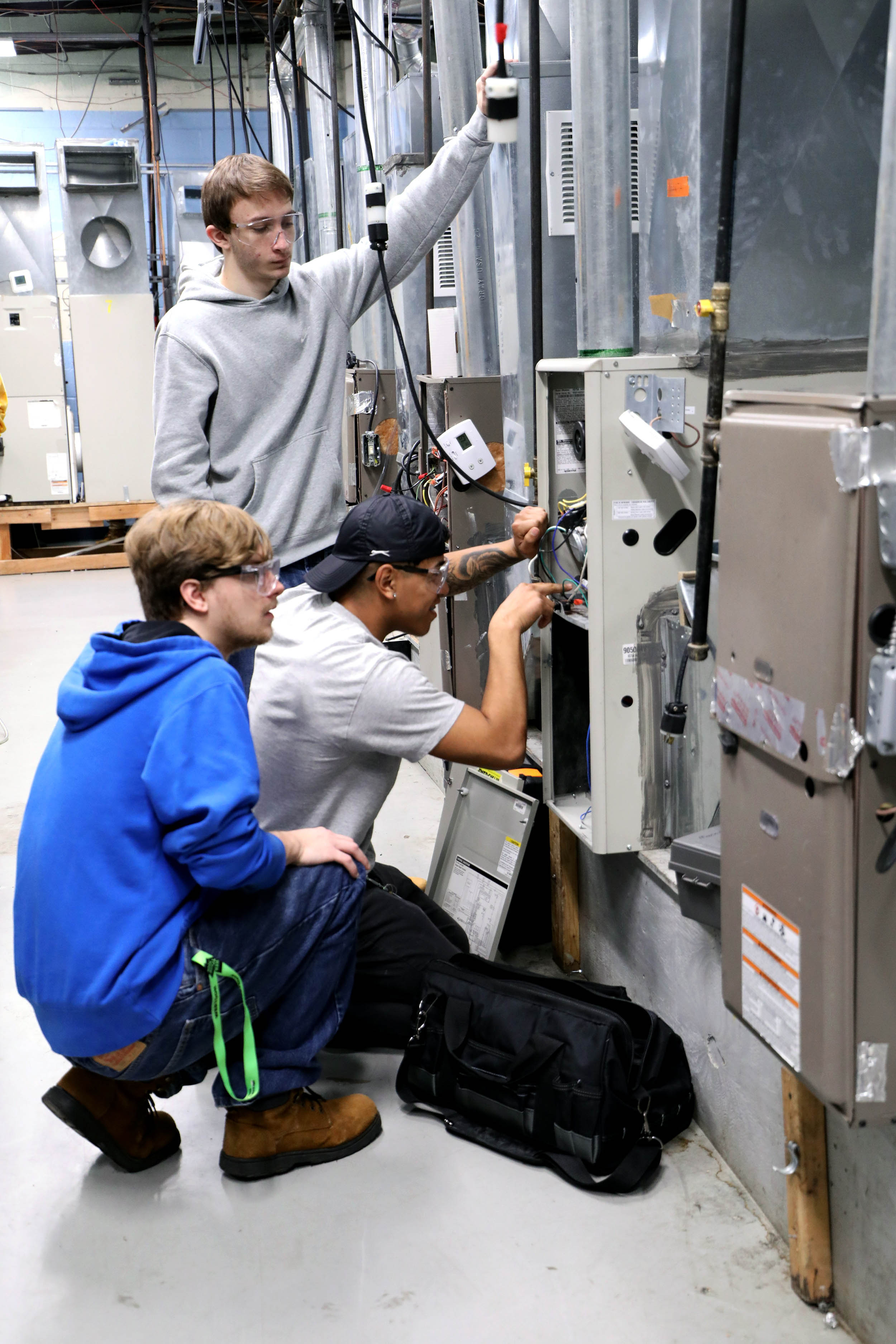 Vocational Students Working on HVAC Unit