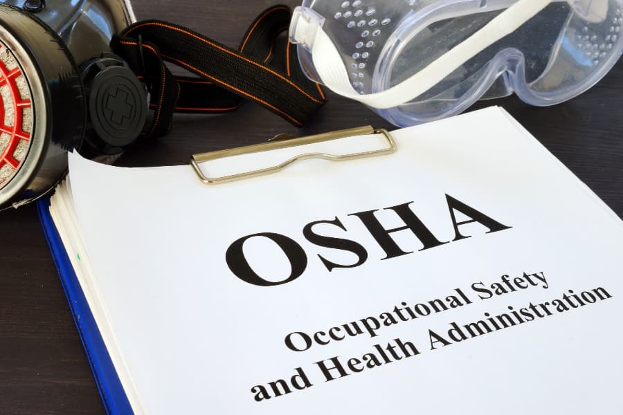 Clipboard with OSHA paperwork and PPE