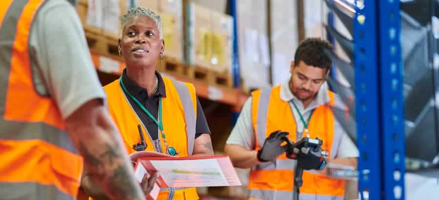 Warehouse manager conducting safety meeting holding binder