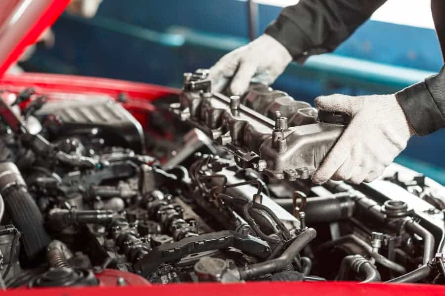 Technician in white gloves working on diesel engine