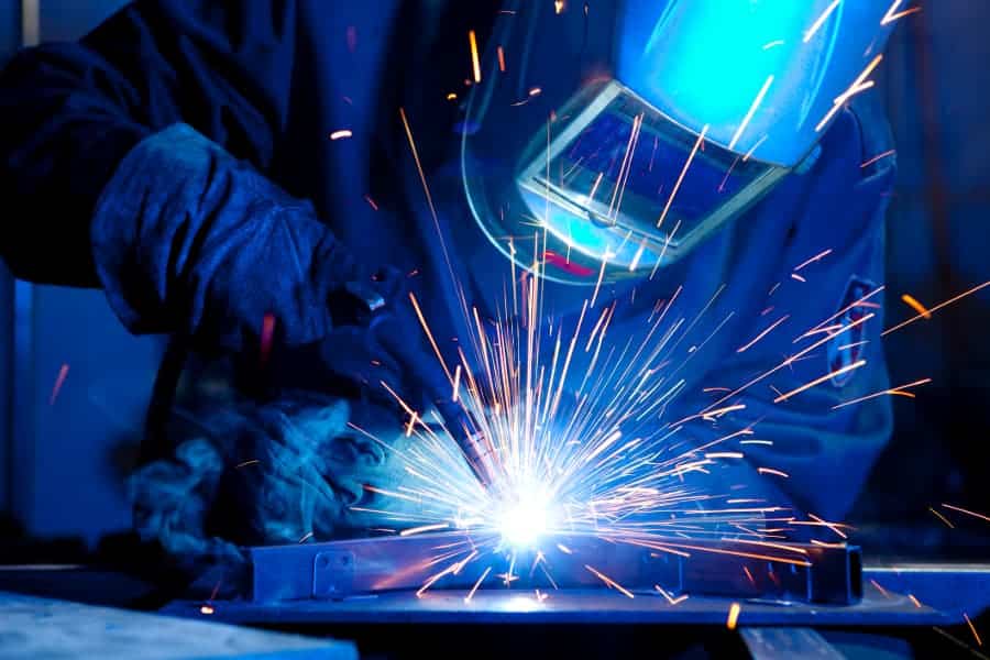 Welder with mask and gloves welding metal